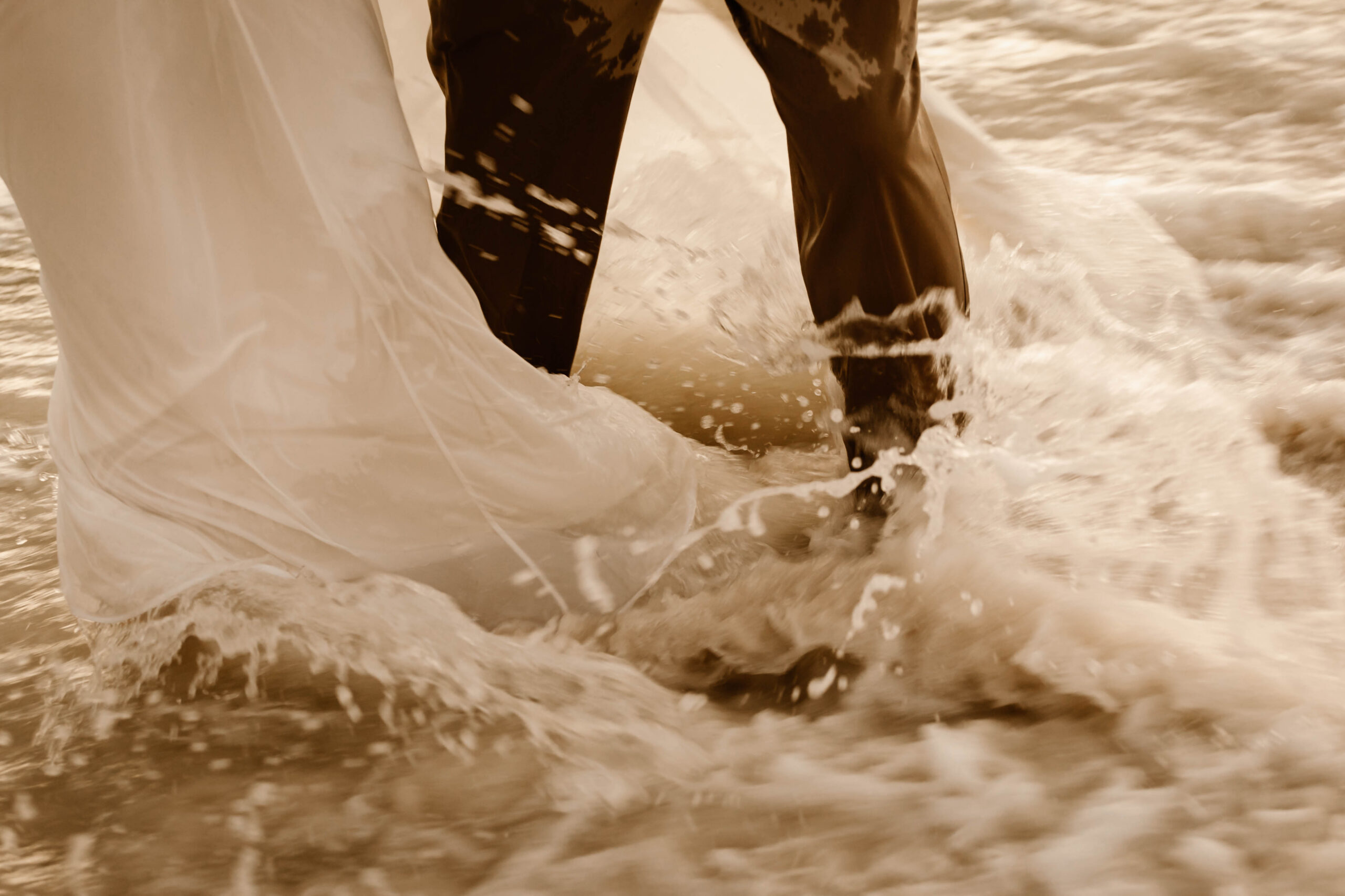 Wedding dress trailing in the waves on a Destin beach at sunset