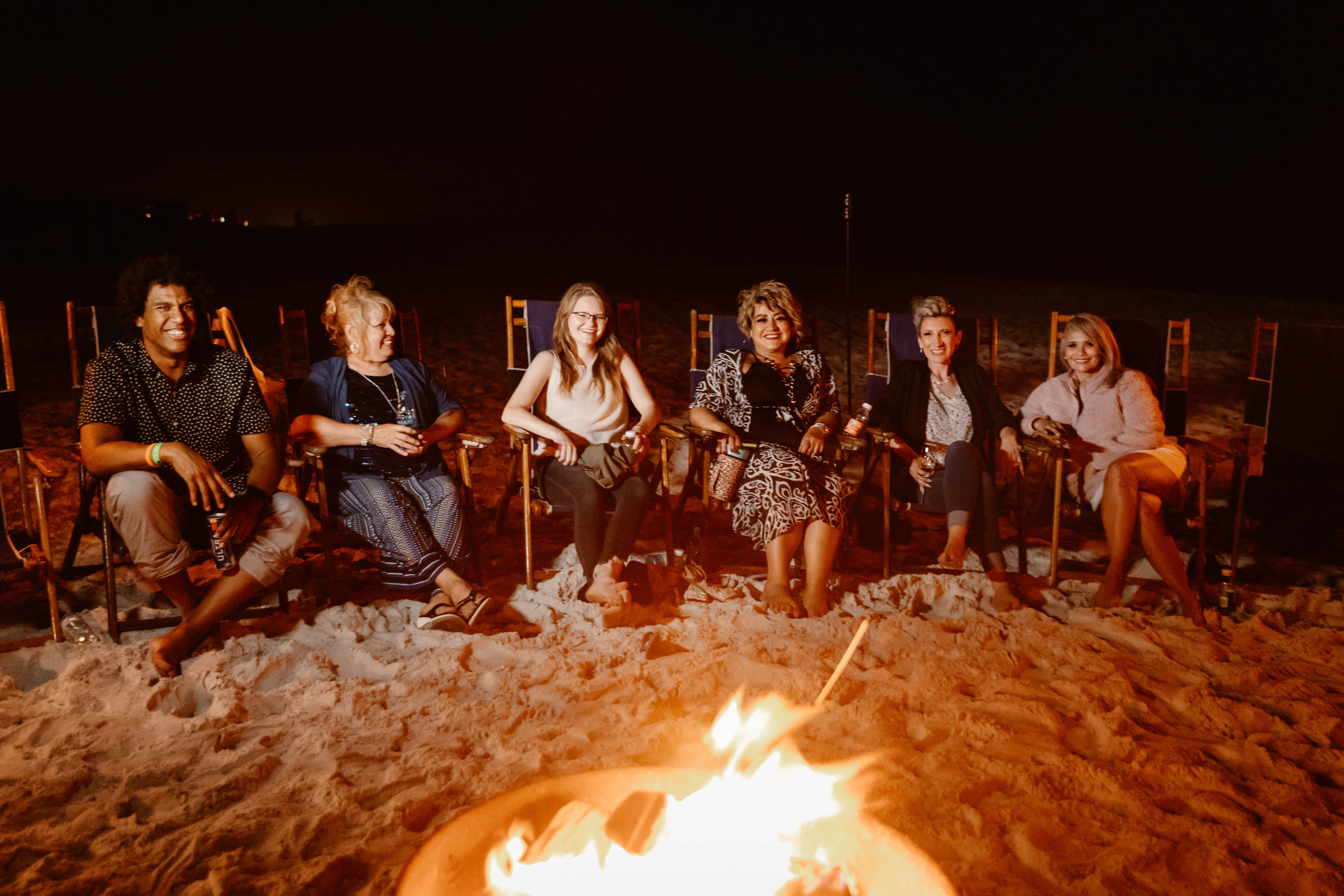 Family gathered around a bonfire on the beach at Fort Panic, Florida
