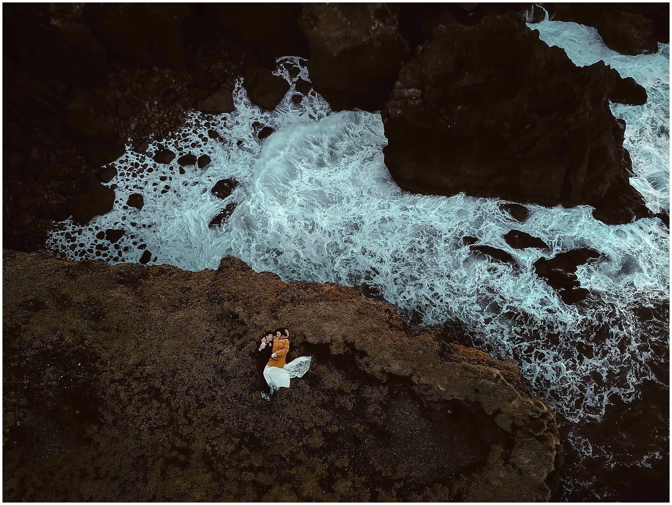 A couple stands among Iceland’s glacial ice